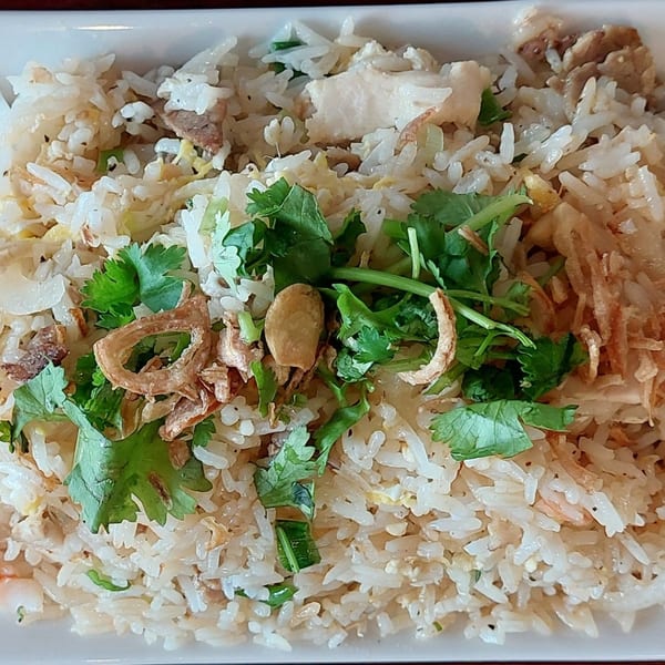 Close-up of Vietnamese fried rice with chicken, cilantro, and crispy fried shallots.